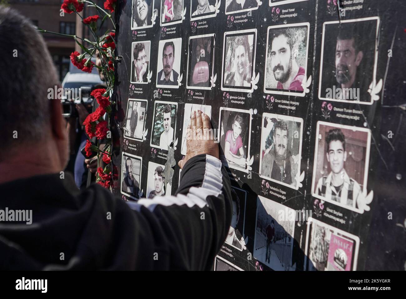 Un homme touche les photos au monument des victimes des attentats-suicides à la bombe de 2015, à Ankara. Septième anniversaire des attentats-suicides à deux lits, au cours desquels plus de 100 personnes ont été tuées (10 octobre 2015), à Ankara, sur 10 octobre 2020. Les kamikazes soupçonnés d'être liés à l'État islamique se sont fait exploser dans une foule de militants pro-kurdes pour la paix qui prévoient d'organiser un rassemblement devant la gare centrale d'Ankara, avec un nombre de morts de 103 personnes. L'attaque l'attaque terroriste la plus meurtrière de l'histoire turque. La septième année du massacre, ceux qui ont perdu leur famille et ceux qui l'étaient Banque D'Images