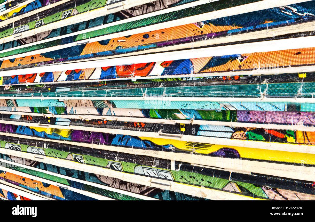 Une vieille collection de bandes dessinées délavées empilées dans une pile crée une texture d'arrière-plan abstraite colorée Banque D'Images