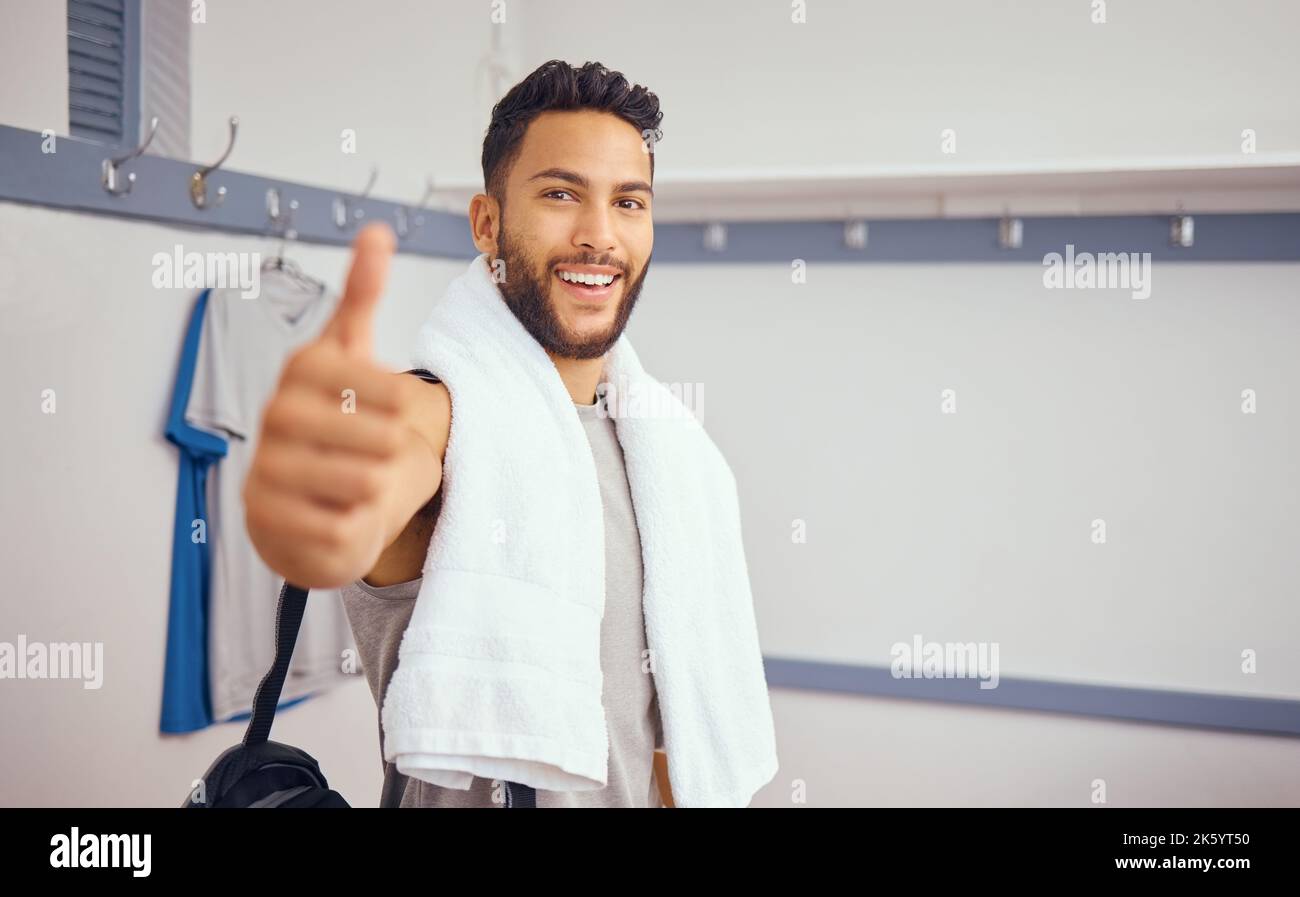 Joueur de course mixte qui donne les pouces dans sa salle de sport. Portrait d'un beau joueur de squash dans son vestiaire de salle de gym. Joueur hispanique professionnel montrant un Banque D'Images