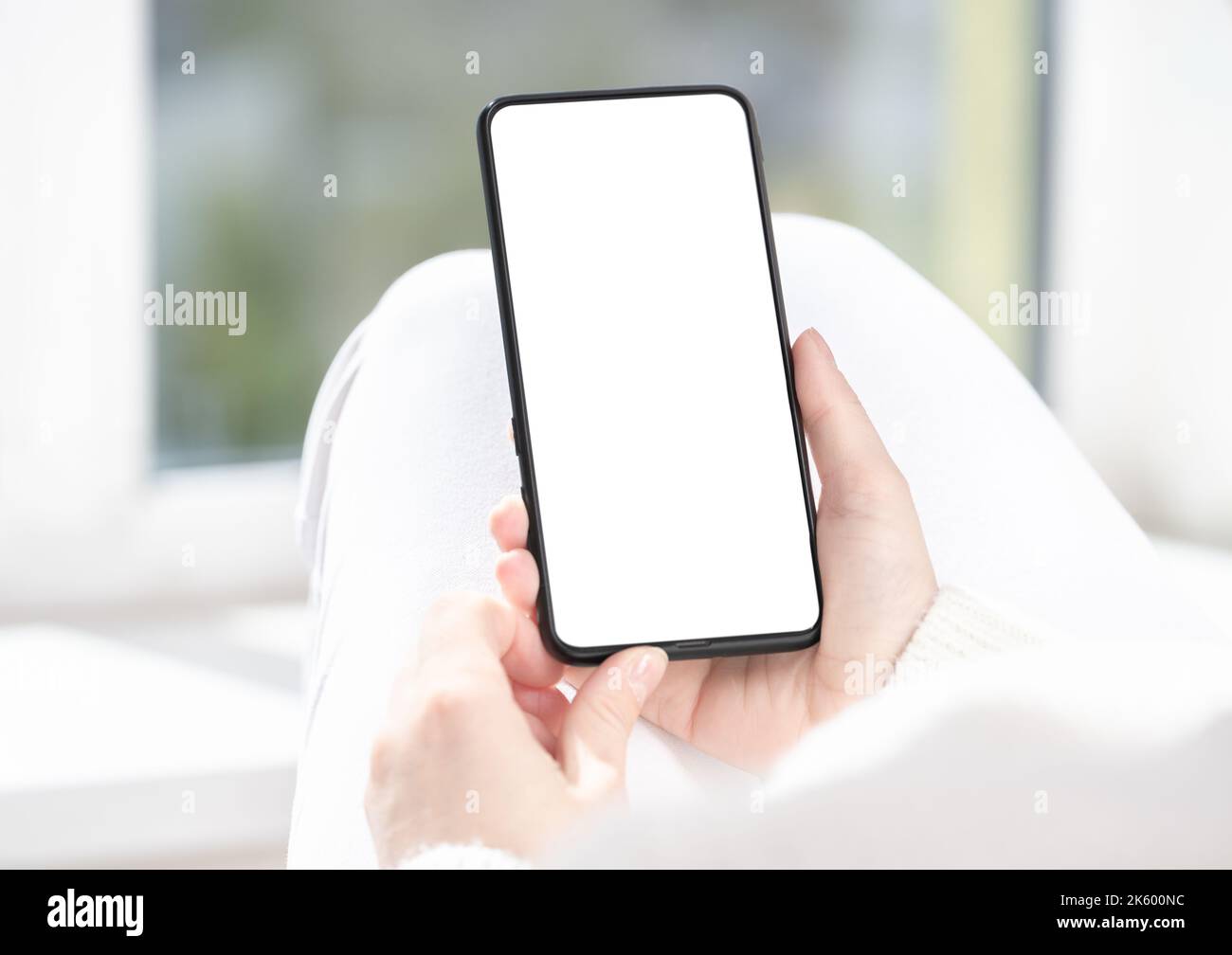 femme utilisateur client tient la maquette de téléphone portable avec écran blanc en main. Utilisez l'application d'achat mobile, consultez les actualités sur les réseaux sociaux, envoyez des SMS mobiles, commandez des aliments d Banque D'Images