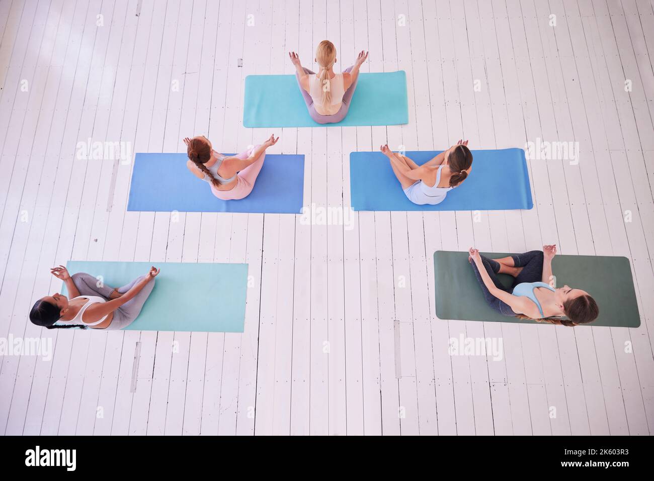 groupe de femmes assis à lotus poser par le dessus. Les femmes en cours de yoga sont assises sur le sol. Des femmes paisibles en posture de yoga assis sur des tapis. Femmes Banque D'Images