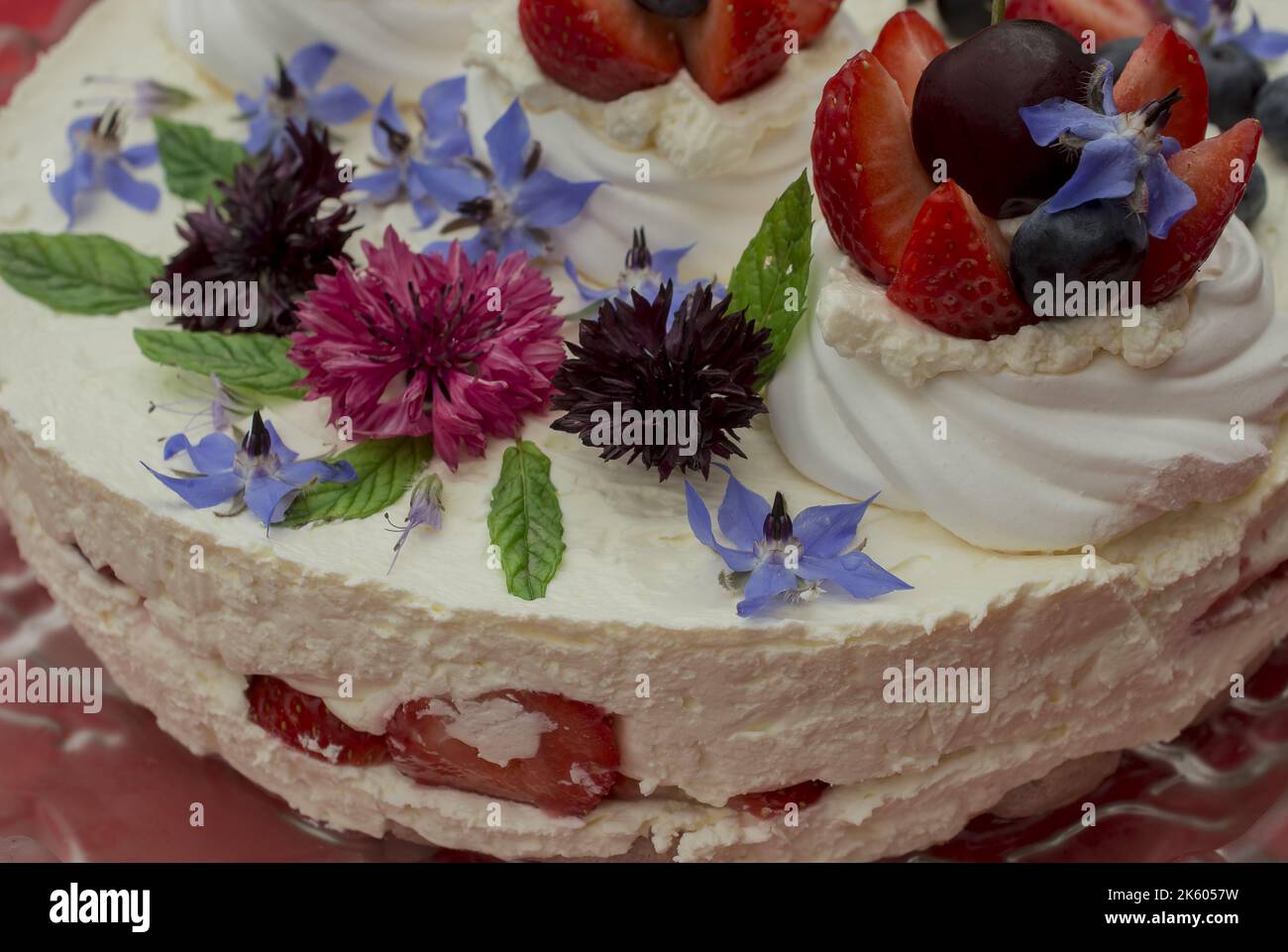 Gâteau crémeux au fromage mascarpone avec fraise et fleurs comestibles Banque D'Images