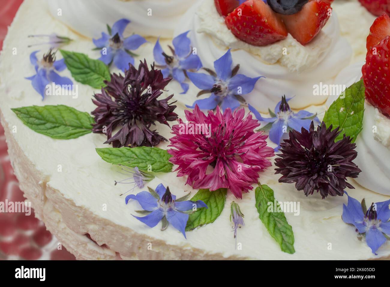 Gâteau crémeux au fromage mascarpone avec fraise et fleurs comestibles Banque D'Images