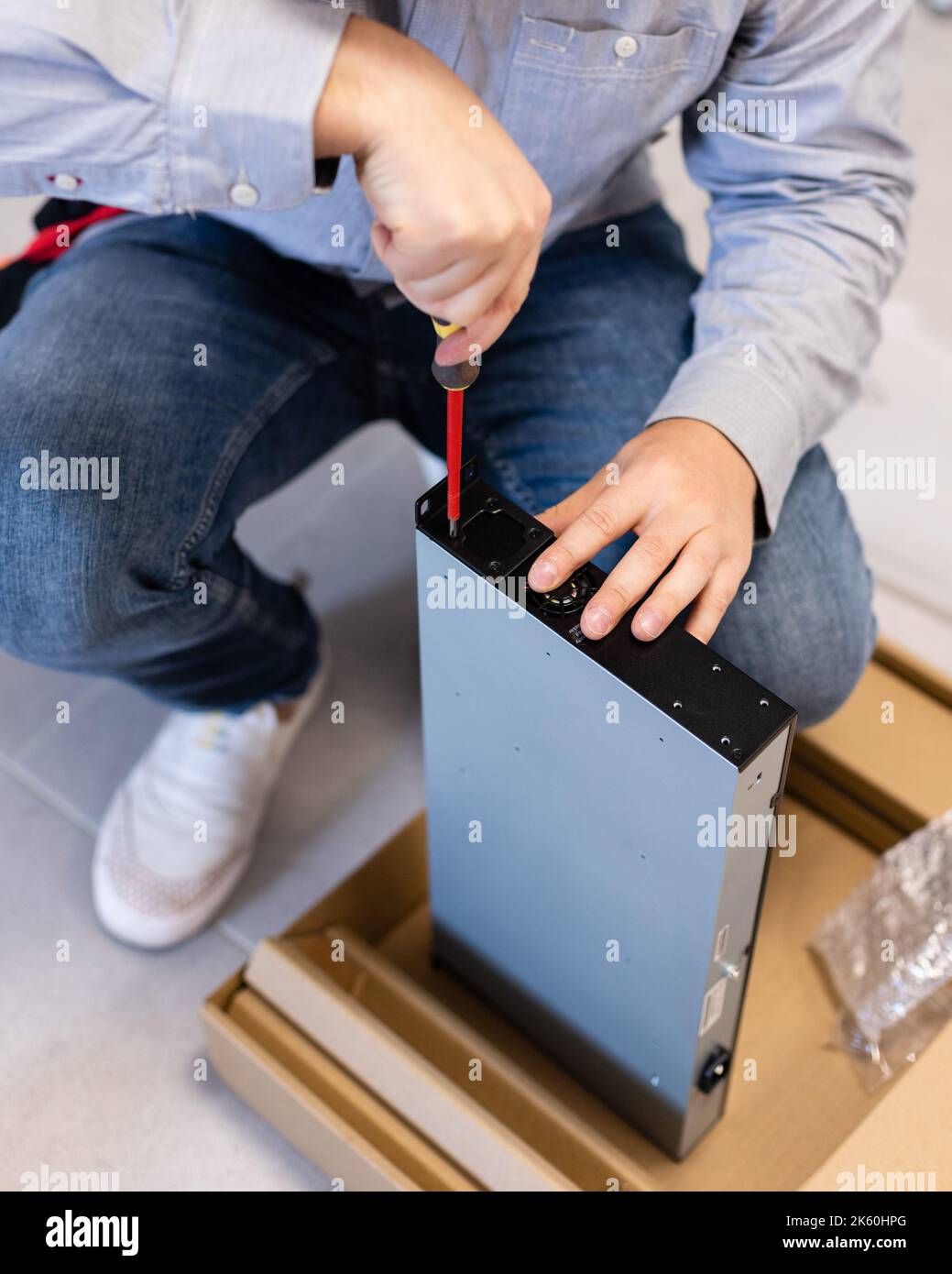 Spécialiste informatique. Installation matérielle et mises à niveau de l'unité système modem pour Internet à l'aide d'un tournevis. Jeune technicien masculin concentré tigh Banque D'Images