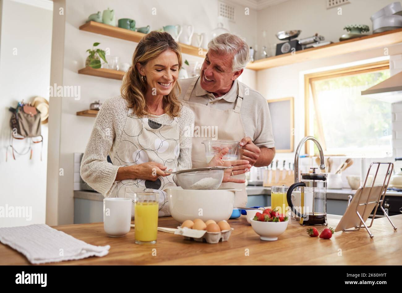 Retraite, couple et cuisine de la nourriture de petit déjeuner avec le sourire heureux dans la cuisine maison du Canada. L'homme et la femme âgés dans le mariage aiment la cuisson du matin Banque D'Images