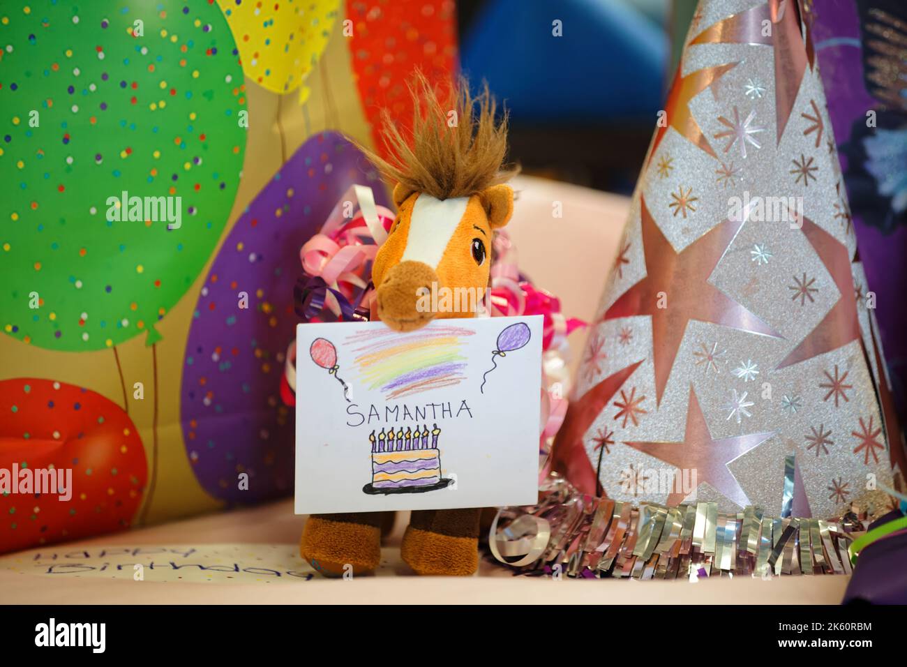 Un adorable cheval en peluche avec une carte d'anniversaire décorée Banque D'Images