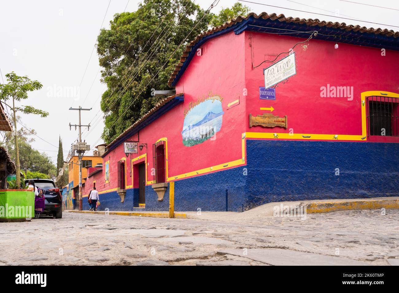 Chapala, Jalisco, Mexique - 10 mai 2021 : façade de bâtiment rouge et bleu sur la rue traditionnelle du village mexicain par la route en pierre de pierre à galets Banque D'Images