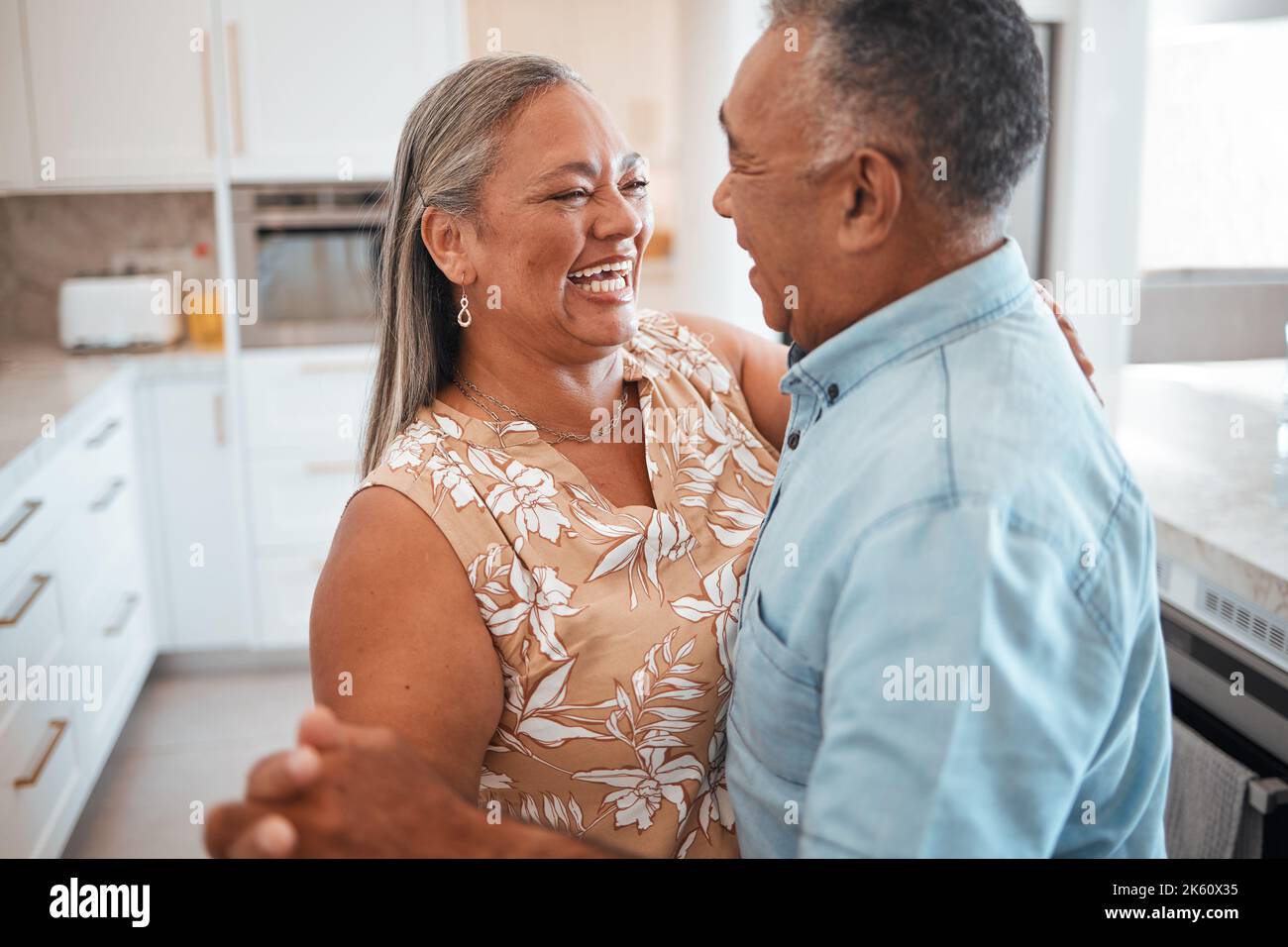 Couple senior dansant dans la cuisine avec célébration pour la retraite, l'immobilier ou le mariage heureux. Les personnes âgées de retraite dansant à la musique avec amour, soin Banque D'Images