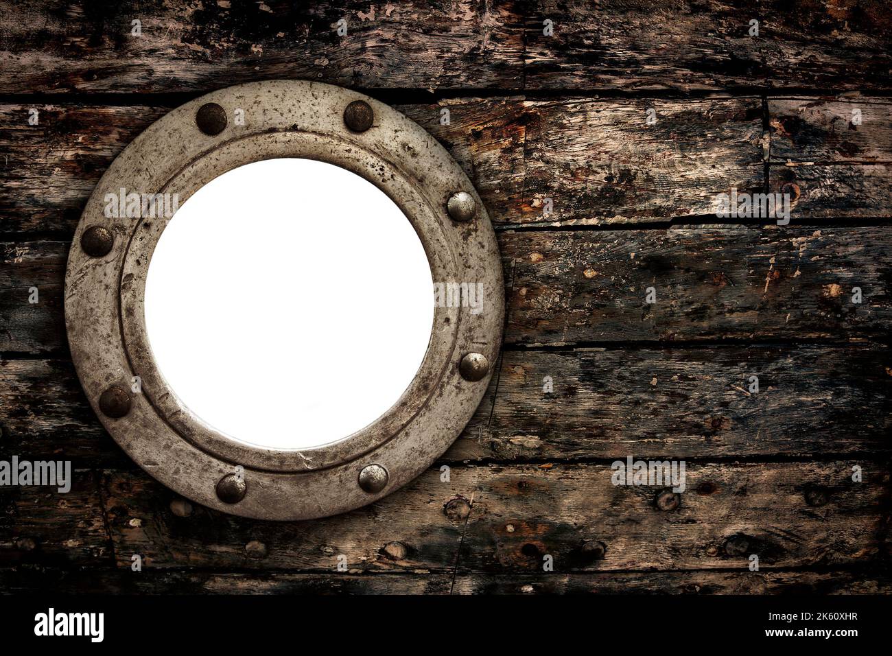 Gros plan d'un vieux hublot vide fermé et rouillé sur de vieilles planches en bois du bateau rétro. Banque D'Images