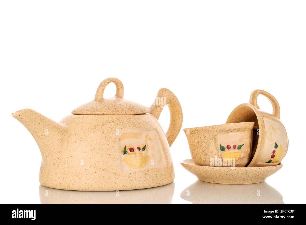 Deux tasses en argile sur une soucoupe et une théière pour faire du thé, macro, isolée sur fond blanc. Banque D'Images