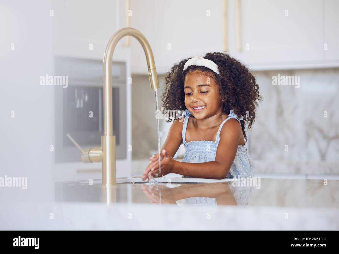 Petite fille, se laver les mains avec le sourire dans la cuisine pour une hygiène saine et propre à la maison. Bonne femme noire de rinçage et de nettoyage de l'enfant à la main près du Banque D'Images