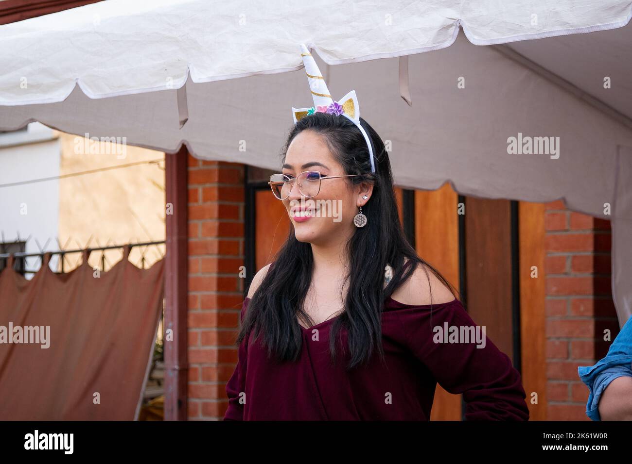 La Paz, Bolivie - 10 septembre 2022 : la bolivienne portant une corne de licorne sur sa tête sourit tout en regardant le spectacle des enfants Banque D'Images
