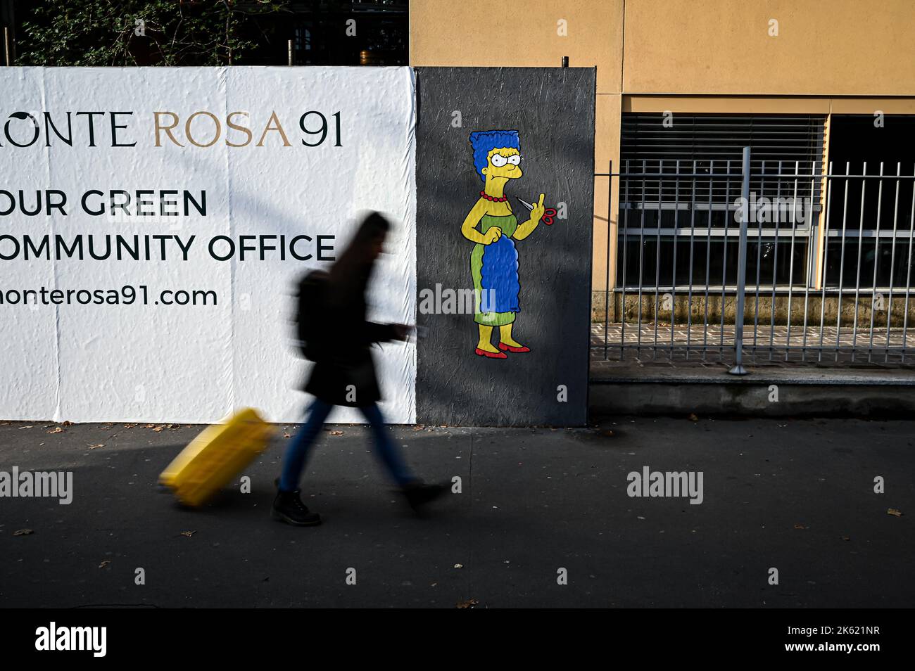 Milan, Italie. 11th octobre 2022. Milan, Italie - 11 octobre 2022: Une femme passe devant une fresque intitulée "The Cut 2" de l'artiste de rue aleXsandro Palombo représentant le personnage des Simpsons Marge Simpson coupant ses cheveux et donnant le doigt du milieu en solidarité avec les femmes d'Iran devant le consulat iranien. Une première version d'une murale similaire, intitulée 'la coupe' est apparue sur 5 octobre au même endroit et a été supprimée plus tard. (Photo de Piero Cruciatti/Sipa USA) crédit: SIPA USA/Alay Live News Banque D'Images