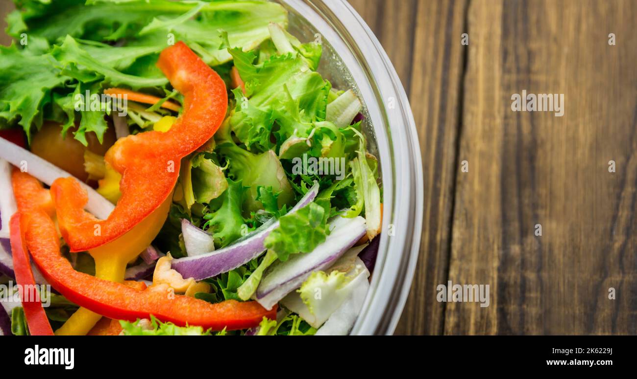 Vue en hauteur de salade de légumes frais dans un bol en verre sur une table en bois, espace de photocopie Banque D'Images