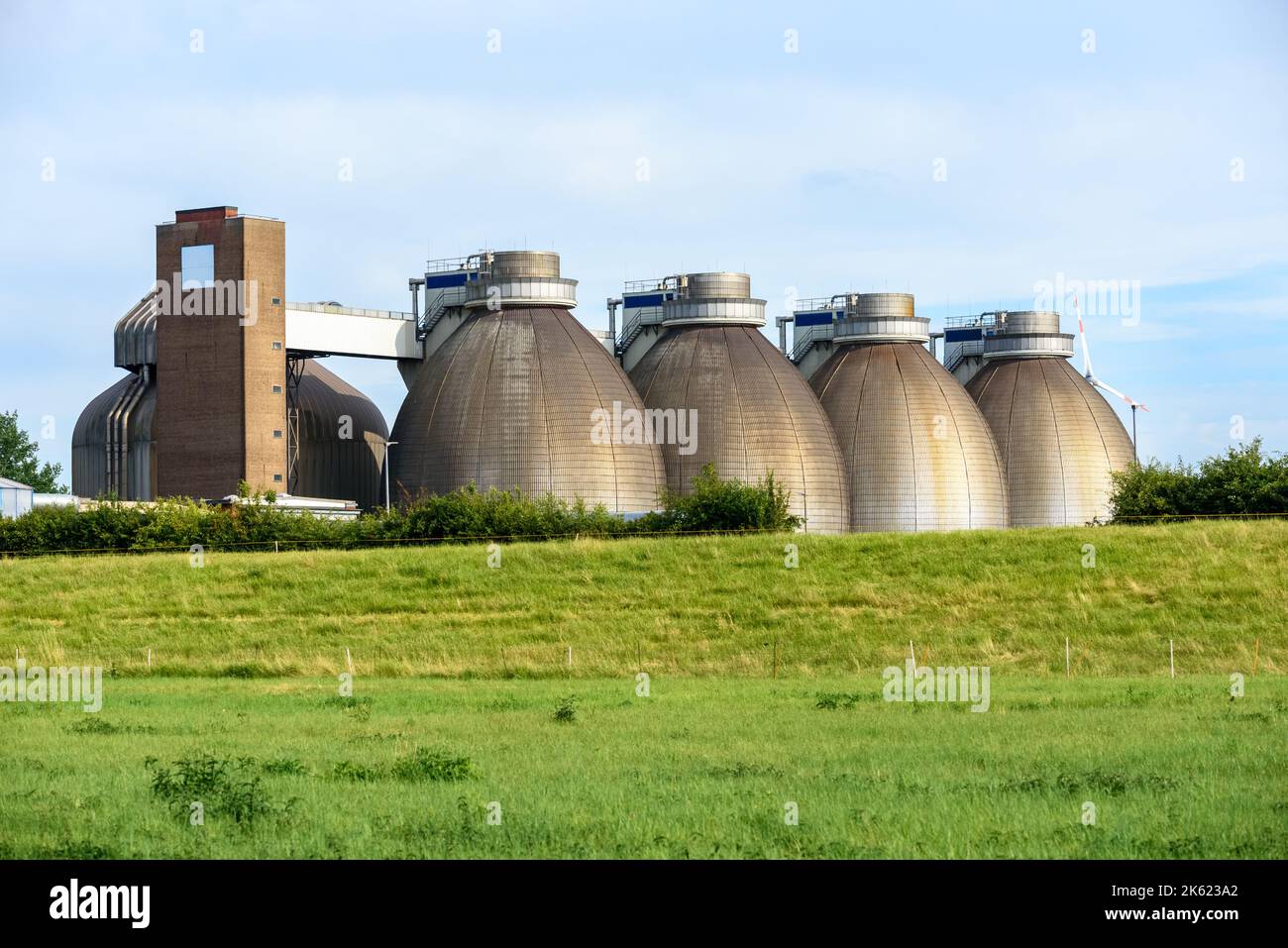 Grands réservoirs en acier dans une installation de stockage des eaux usées au coucher du soleil Banque D'Images