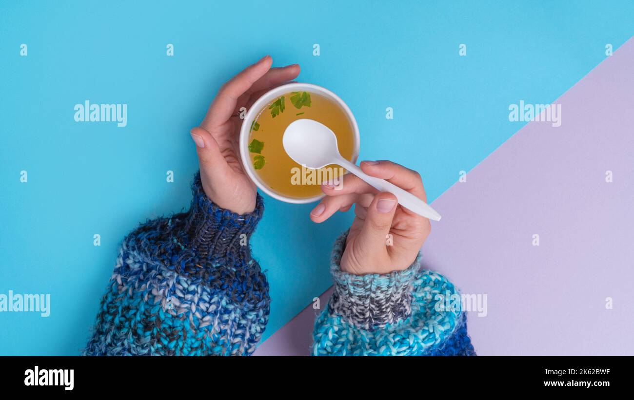 Manger une soupe de bouillon de poulet dans un gobelet à emporter Banque D'Images