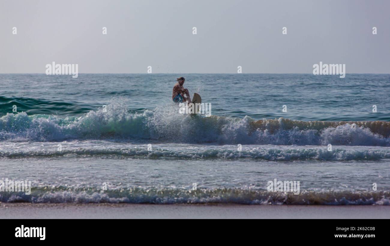 Un homme surfe sur une planche de surf sur la plage d'Agadir Banque D'Images Un homme surfe sur une planche de surf sur la plage d'Agadir Banque D'Images