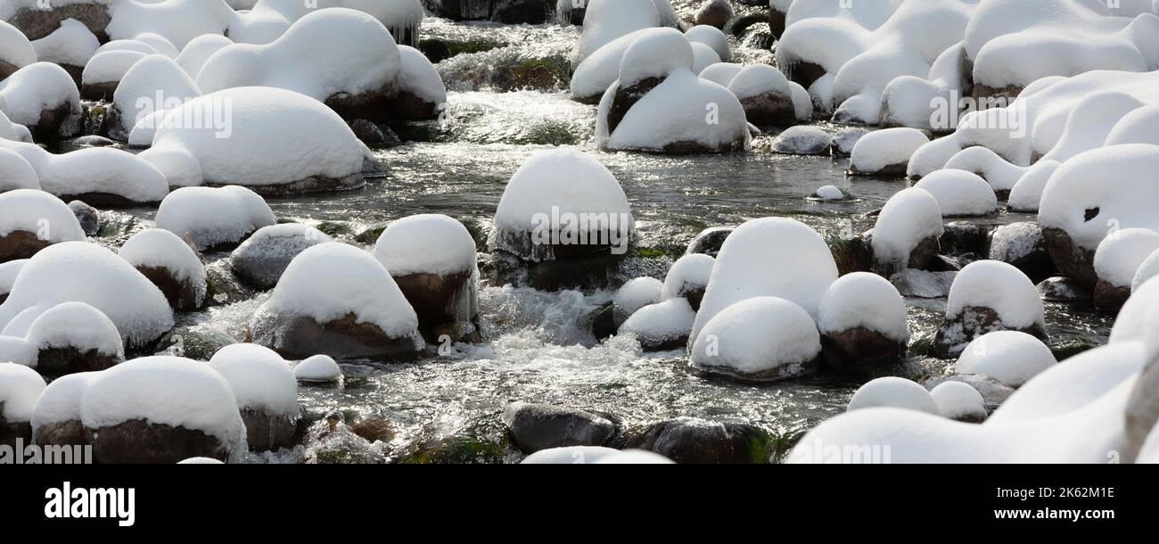 Bannière d'hiver avec pierres enneigées sur la rivière Banque D'Images