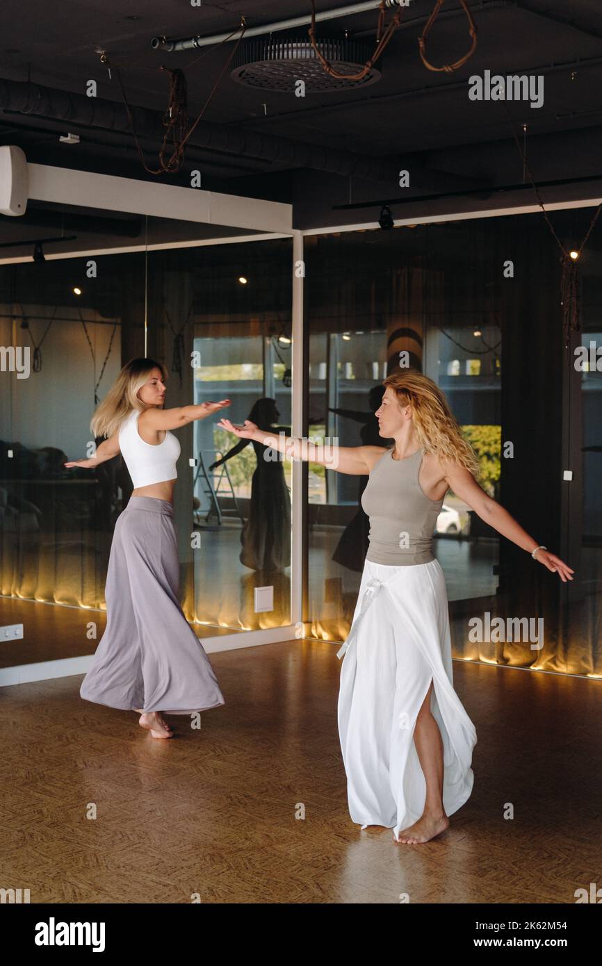 Deux femmes en vêtements de sport font du yoga de danse dans la salle de gym Banque D'Images