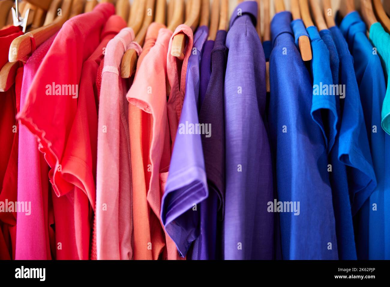 Vêtements durables colorés suspendus sur rail dans la Charité ou magasin Thrift vendant la mode durable Banque D'Images