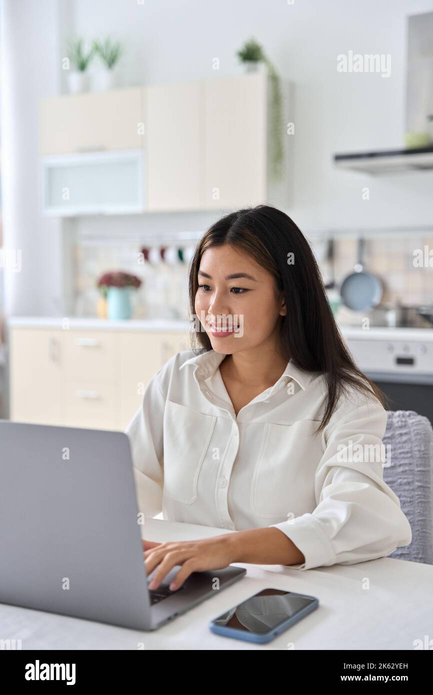 Jeune femme pigiste étudiante asiatique souriante utilisant un ordinateur portable pour le travail à distance Banque D'Images