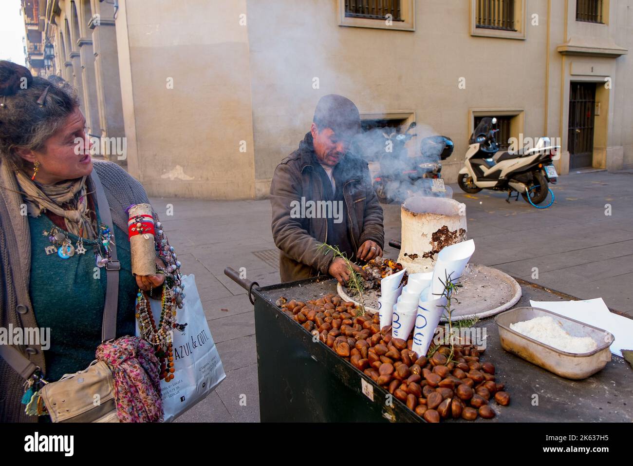 Homme torréfaction de noix, stand de nourriture de rue, Séville, Espagne Banque D'Images