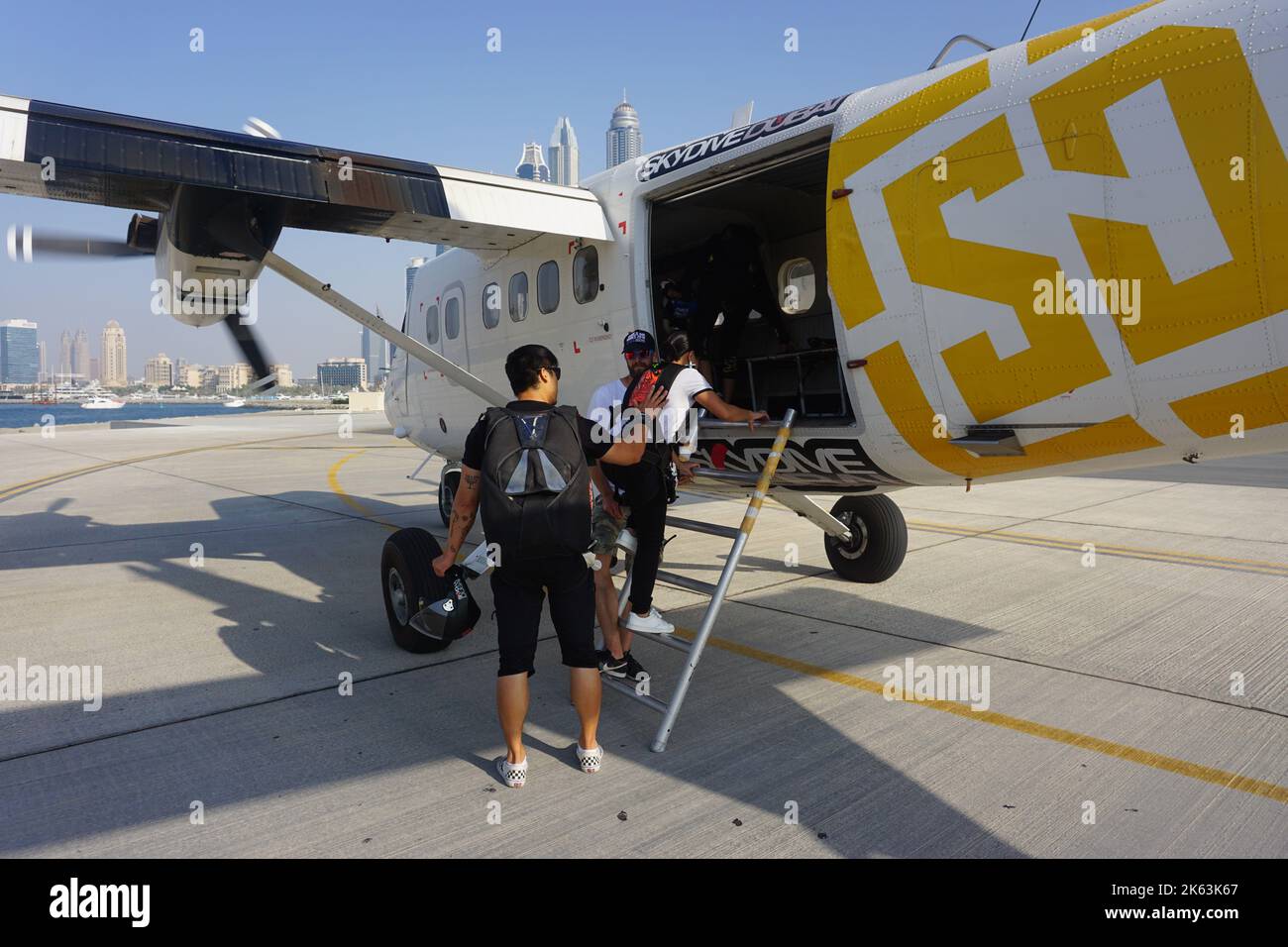 Dubaï, Émirats arabes Unis - femmes débutants planches Skydive avion Dubaï, instructeur de tandem de parachutisme masculin derrière elle. Piste d'atterrissage à la zone de dépôt des palmiers. Banque D'Images Dubaï, Émirats arabes Unis - femmes débutants planches Skydive avion Dubaï, instructeur de tandem de parachutisme masculin derrière elle. Piste d'atterrissage à la zone de dépôt des palmiers. Banque D'Images
