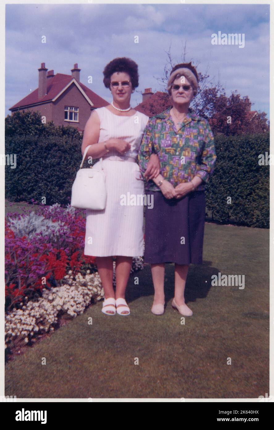 Une mère et une grand-mère dans leur dimanche d'été le mieux, posant pour une photo dans un arrière-jardin britannique de banlieue très soigneusement gardé. Banque D'Images