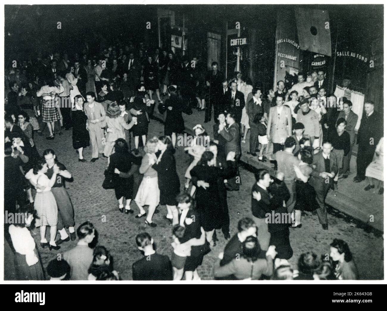 WW2 - Célébrations de la victoire à Paris, France - Parisiens dansant dans la rue, illuminés par la lumière de l'amultitude de feux d'artifice multicolores. Banque D'Images