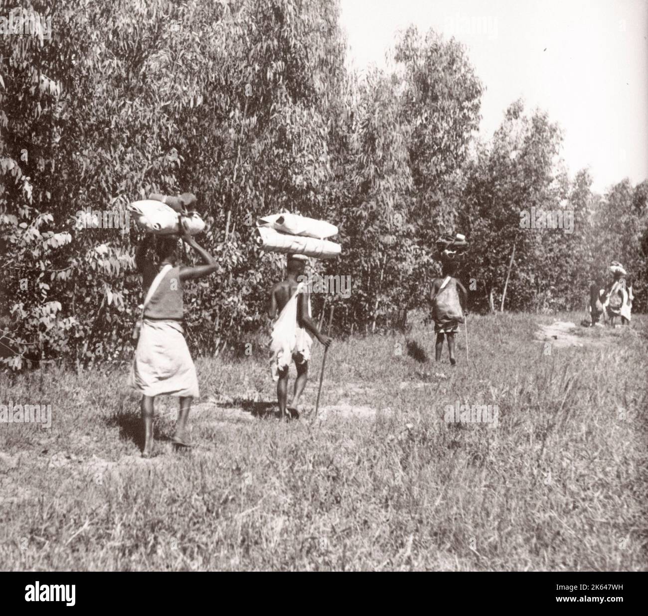 1940s Afrique de l'est - Ouganda - travailleurs migrants du Congo avec leurs paquets de voyage Photographie d'un officier de recrutement de l'armée britannique stationnés en Afrique de l'est et au Moyen-Orient pendant la Seconde Guerre mondiale Banque D'Images