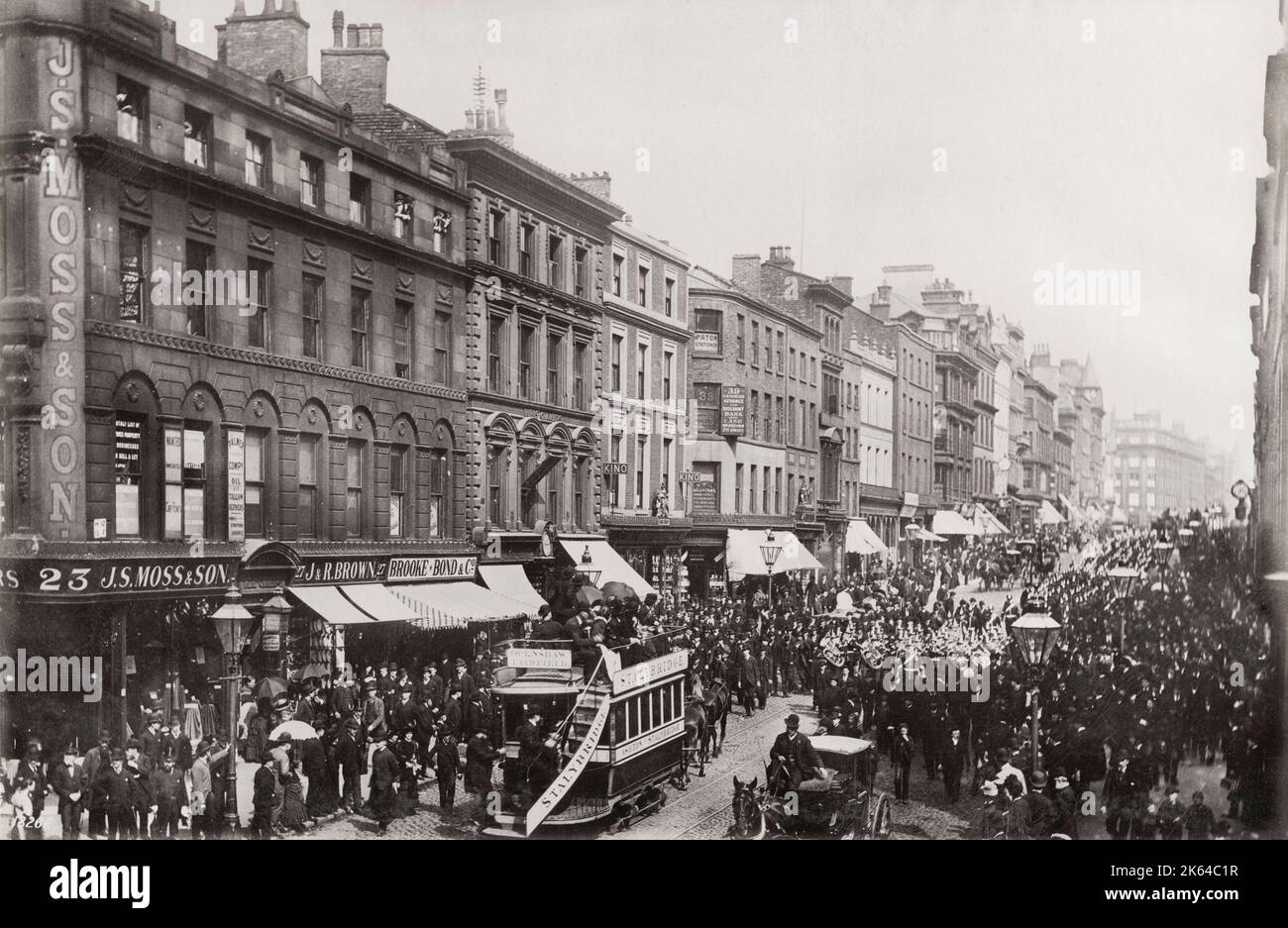 Photographie vintage du 19th siècle : procession dans une rue animée de Londres, piétons, tramways, bracelet en laiton. Image c.1890. Banque D'Images
