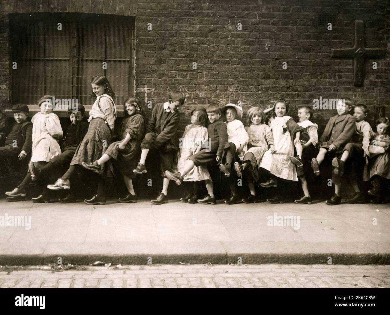 Groupe d'enfants de la classe ouvrière de Londres montrant outre de nouveaux sabots qu'ils ont été donné c.1920s Banque D'Images