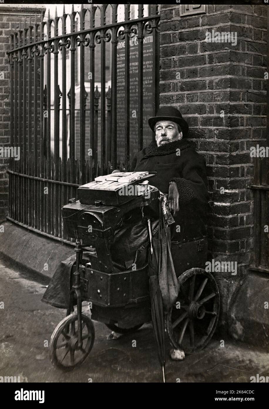 Une mobilité vendeur d'allumettes et lacets sur un coin de rue de Londres, c.1920s. Banque D'Images