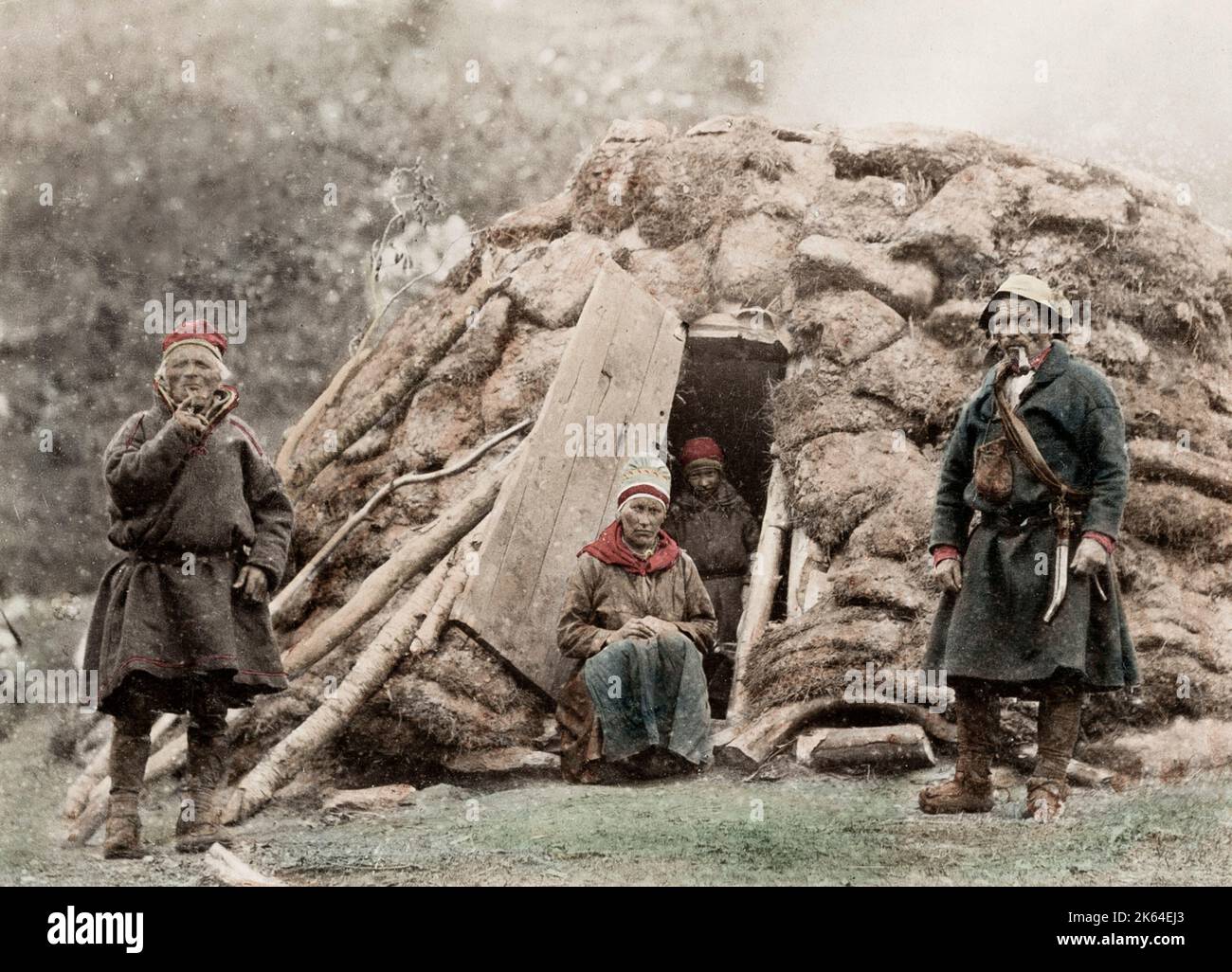 Photographie vintage du 19e siècle : groupe de Sami devant leur maison, vers 1890. Le peuple Sami est un peuple indigène finno-ougrien habitant Sapmi, qui englobe aujourd'hui de grandes parties du nord de la Norvège, de la Suède, de la Finlande et de la péninsule de Kola dans l'oblast de Mourmansk en Russie. Banque D'Images