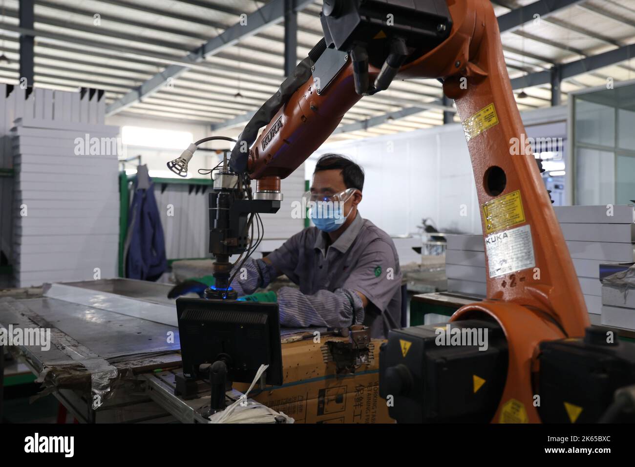 BINZHOU, CHINE - 12 OCTOBRE 2022 - Un travailleur utilise des appareils intelligents pour produire des ustensiles de cuisine dans un atelier d'une entreprise de fabrication d'ustensiles de cuisine à Banque D'Images