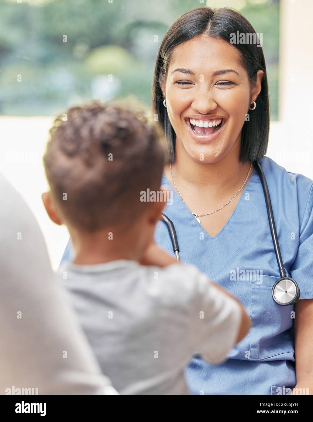 Infirmière soignante travaillant avec une famille. Une infirmière sympathique parlant à une petite patiente pendant la visite à l'hôpital avec son père Banque D'Images