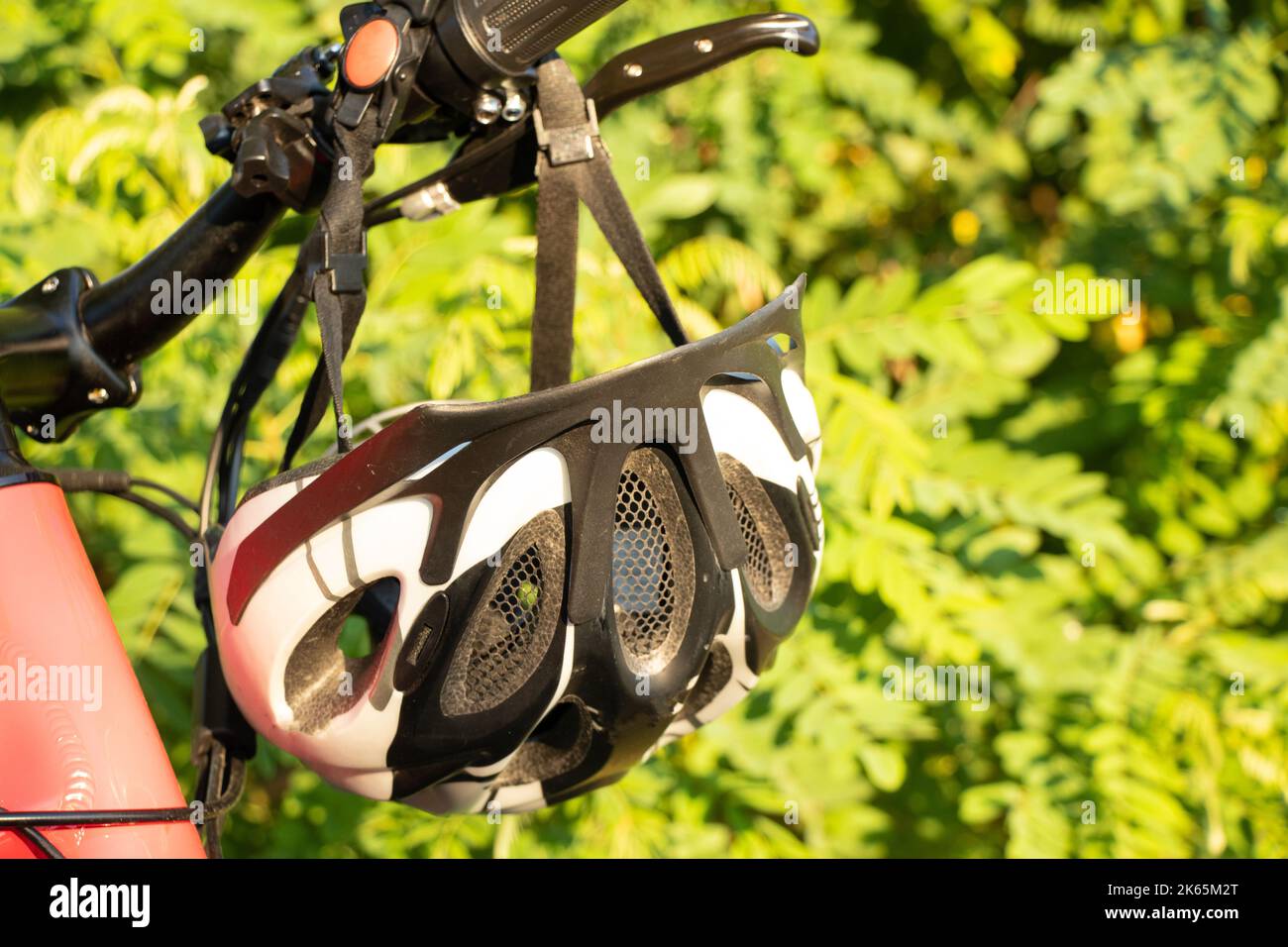 casque de vélo sur le guidon d'un e-bike au coucher du soleil dans la nature, casque de vélo sur un vélo Banque D'Images