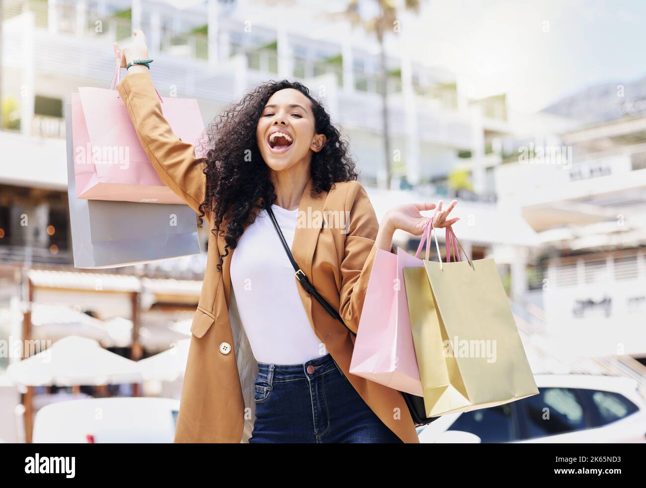 Vente au détail, shopping et sacs avec une femme en ville pour la mode, l'été et le cadeau pour un style de vie riche. Luxe, ventes et wow avec une fille heureuse client dans la rue Banque D'Images