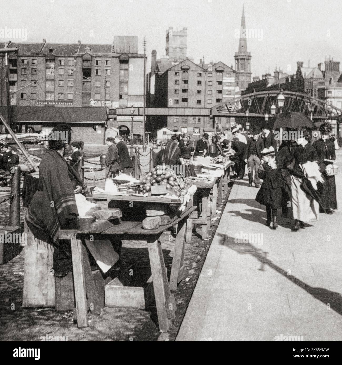 Une vue du début du 20th siècle des commerçants de rue sur le front de mer de Liverpool, en Angleterre. Un pont du chemin de fer de quai peut être vu derrière. Banque D'Images