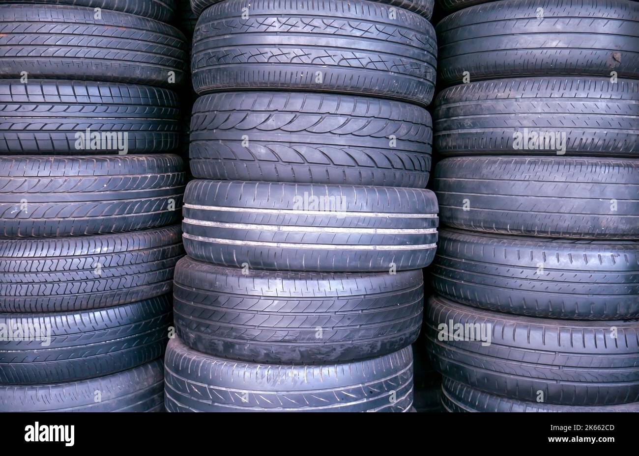 Les pneus de voiture d'occasion et d'ancienne taille s'empilent dans l'atelier de réparation des pneus Banque D'Images