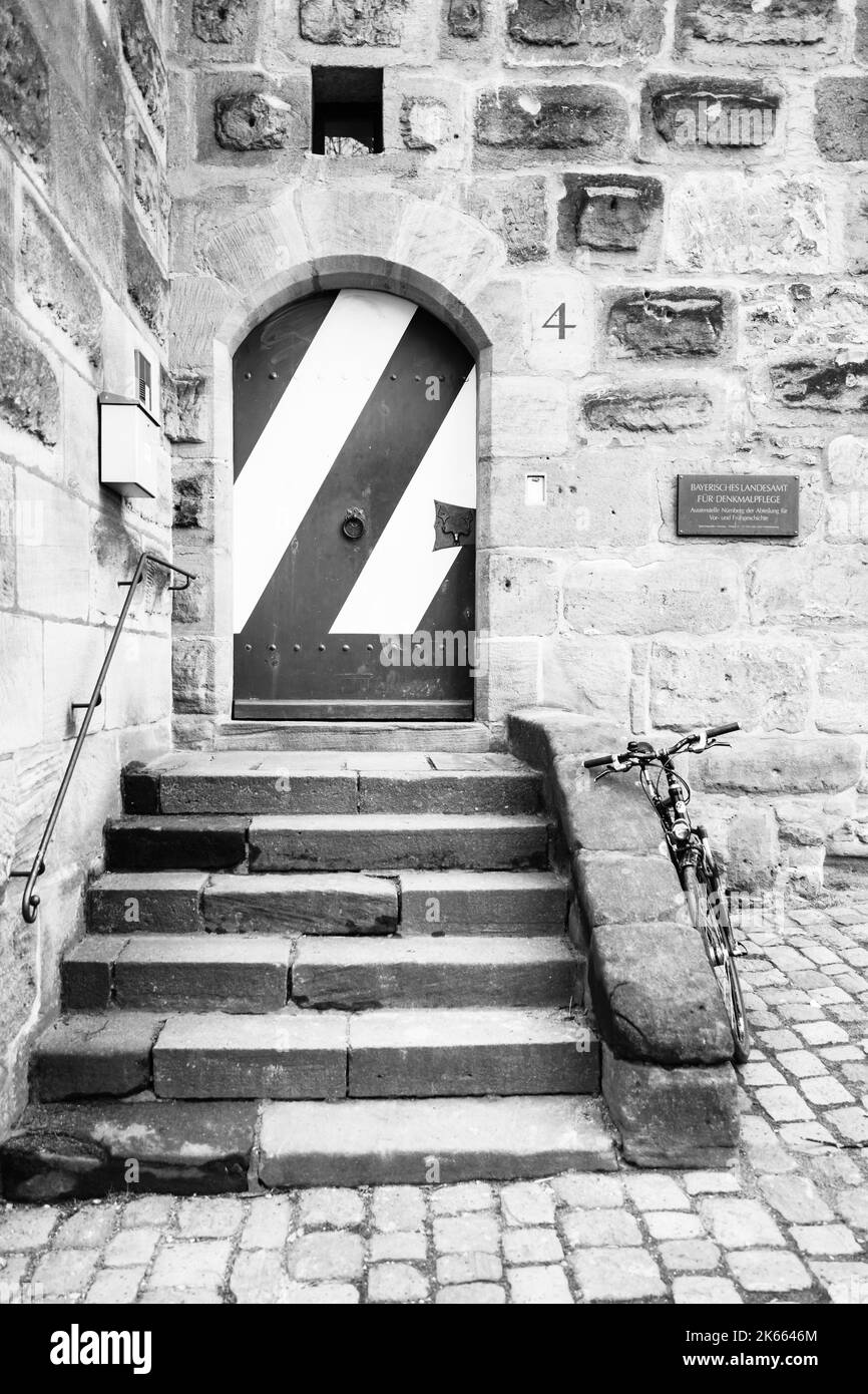 Stariway à porte en métal avec vélo stationné près du mur. Noir et blanc. Banque D'Images