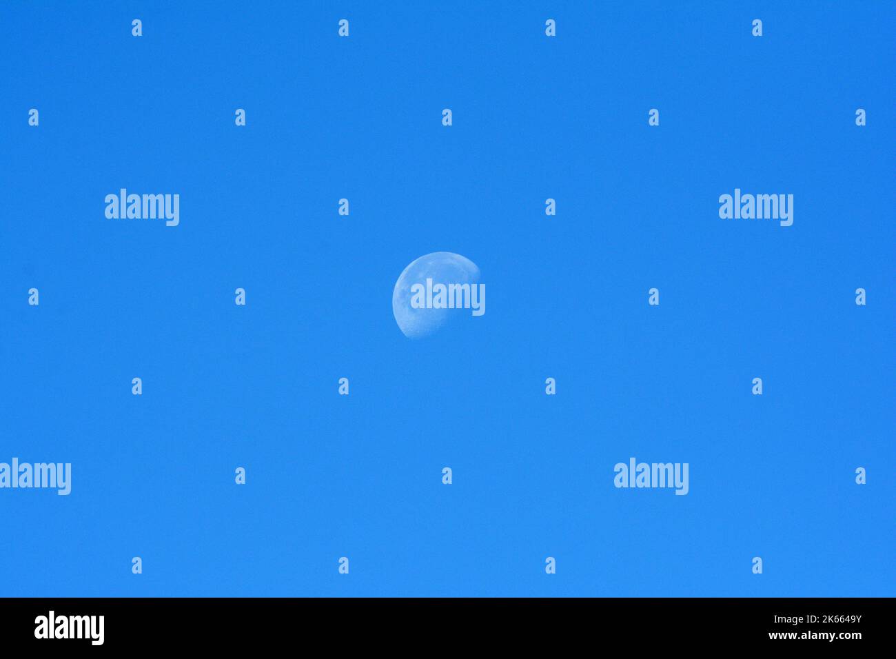 une lune pendant une journée dans le ciel bleu Banque D'Images