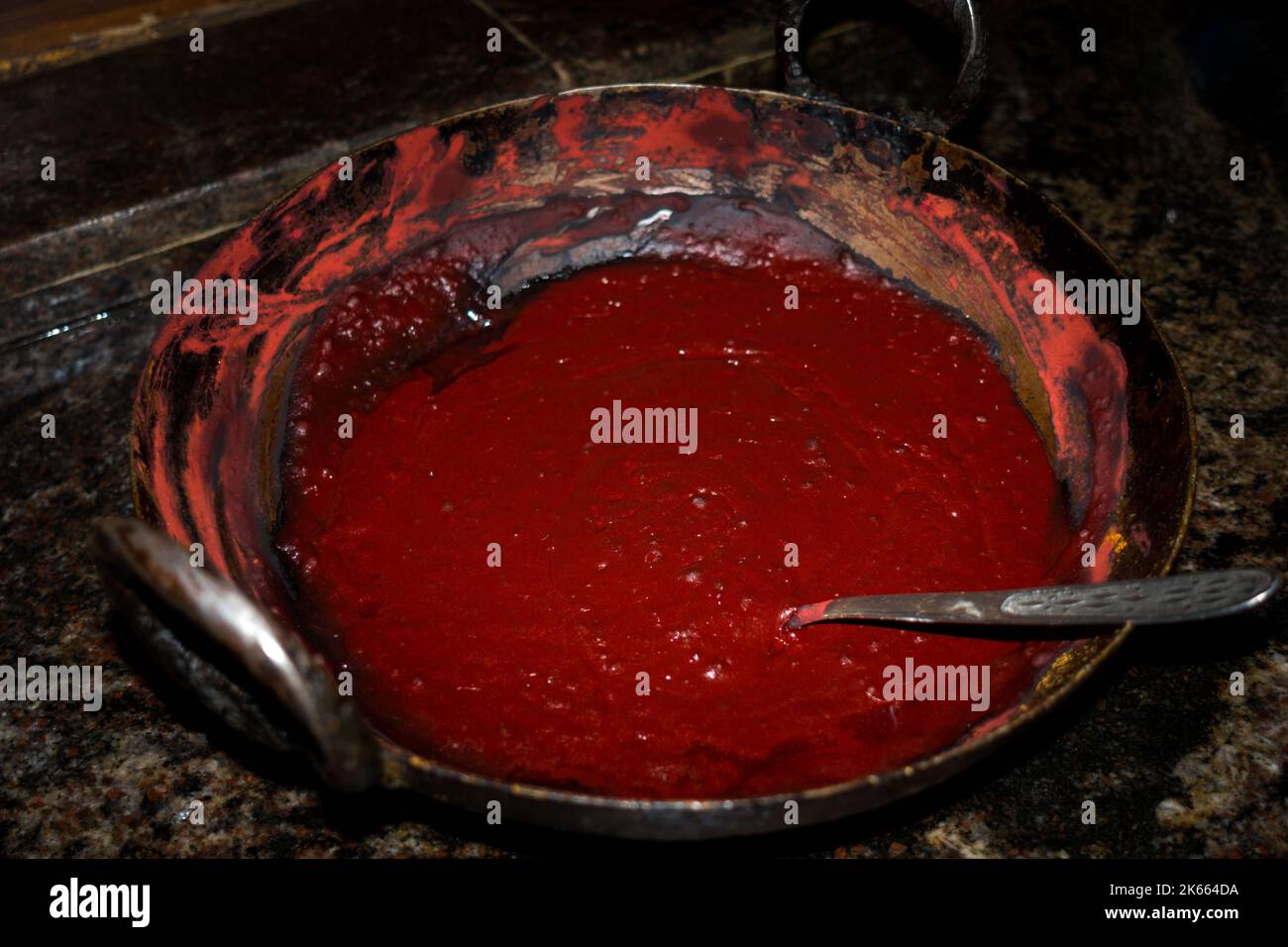 Colorant de henné ou Mehendi (Lawsonia inermis) fait dans un kadai en fonte. Un colorant rougeâtre-brun fait à partir des feuilles en poudre d'un arbuste tropical, utilisé pour le col Banque D'Images