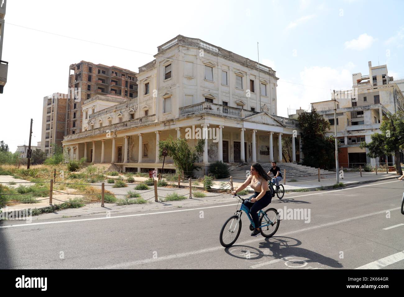 Les touristes dans les rues désertes de Varosha passent devant l'opéra abandonné, la « ville fantôme » de Famagust.Repulic turc du nord de Chypre Banque D'Images