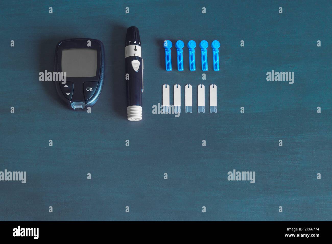 Un glucomètre et ses fournitures pour vérifier les niveaux de sucre dans le sang. Concept de diabète de fond bleu. Banque D'Images