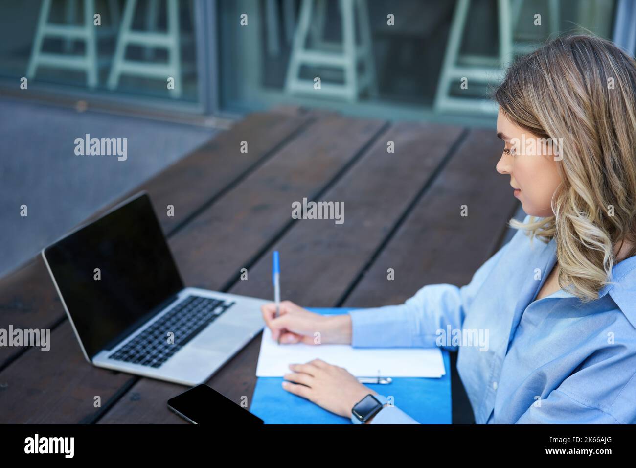 Portrait d'une femme d'affaires prenant des notes, étudiant sur son ordinateur, assis à l'extérieur dans le parc. Jeune femme qui écrit, visioconférence sur ordinateur portable Banque D'Images