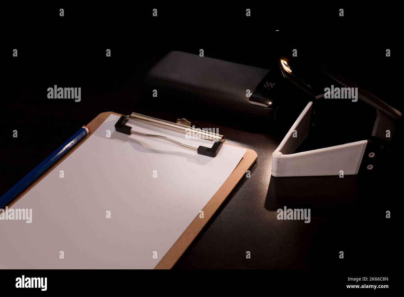 bloc-notes lumineux avec mobile et banque d'électricité sur le bureau, concept de pauvreté énergétique pannes d'électricité Banque D'Images