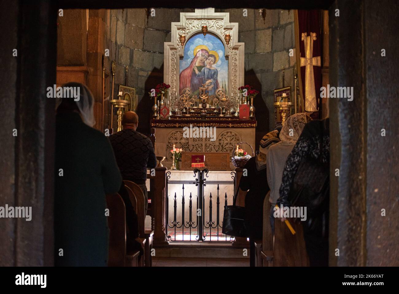 Une icône de la Vierge Marie et de Jésus sur l'alter avec des gens qui prient devant elle, Erevan, Arménie Banque D'Images