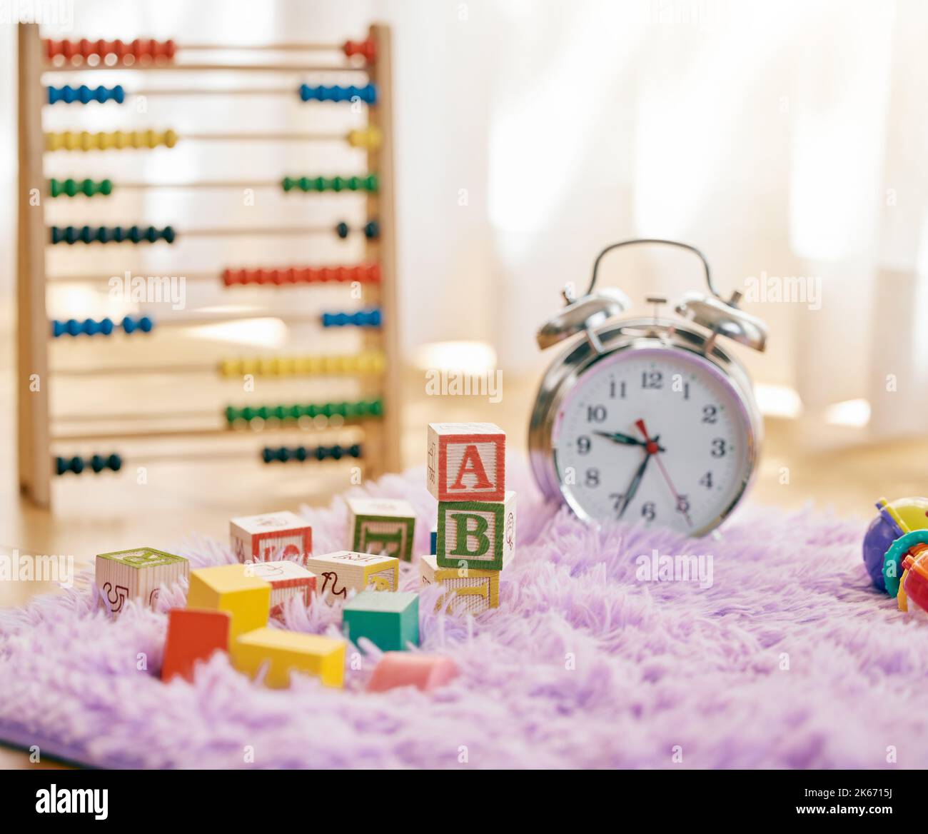 Son temps d'apprentissage. Photo de la vie d'une horloge et de plusieurs jouets sur un tapis moelleux. Banque D'Images