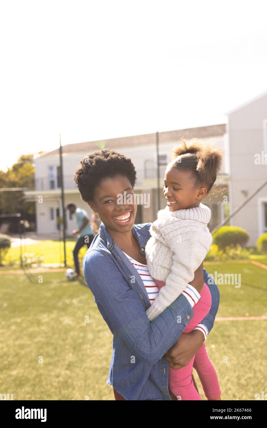 Bonne mère et fille afro-américaine passant du temps ensemble et jouant au football à l'extérieur Banque D'Images